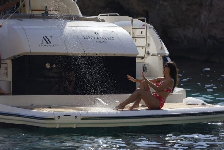 Girl getting splashed on back of yacht